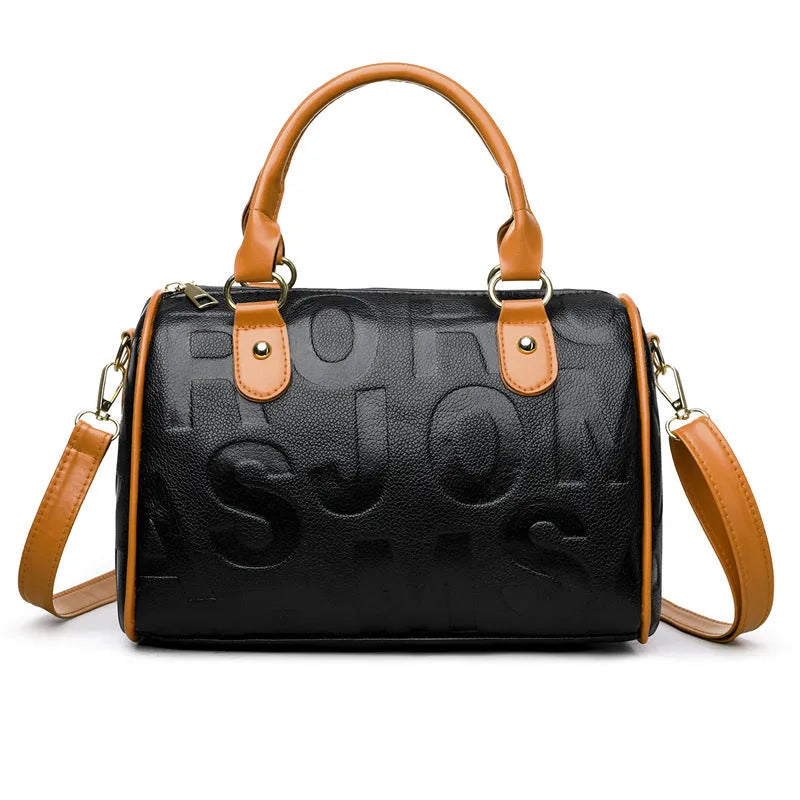 Brown cylindrical leather-effect crossbody bag with three shoulder straps on a table.