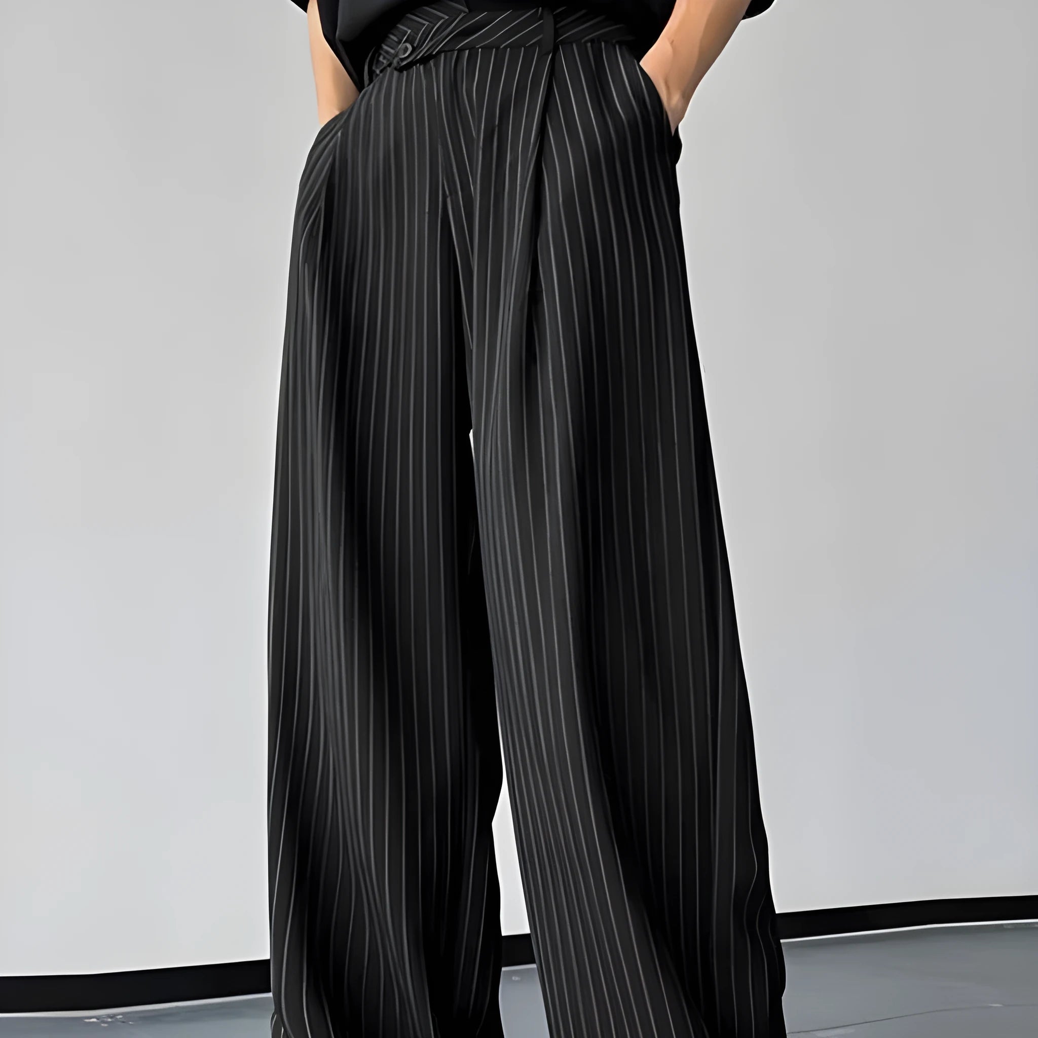 Black men's casual trousers with vertical stripes and front pleats laid flat.