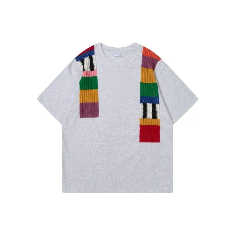 Men's loose fit grey T-shirt with a black and white patchwork letter design on the chest.