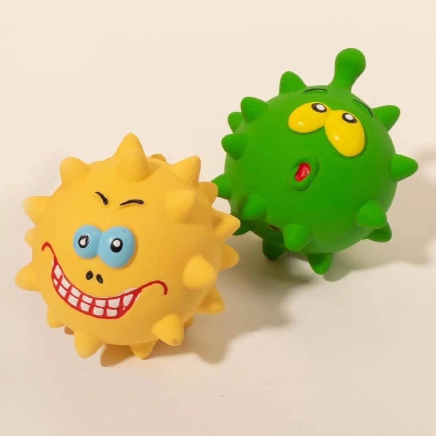 Four colourful natural latex dog squeaky balls with textured surfaces and cute faces