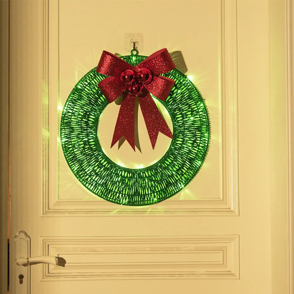 50cm gold green tinsel Christmas garland with LED lights and big bowknot on a wooden door