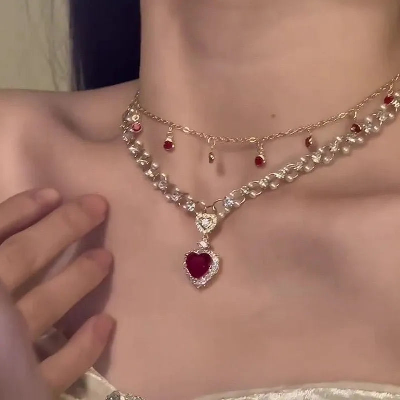 Red double layer necklace with twin chains, a pearl pendant, and a love heart pendant on an adjustable alloy chain.
