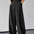 Black men's casual trousers with vertical stripes and front pleats laid flat.