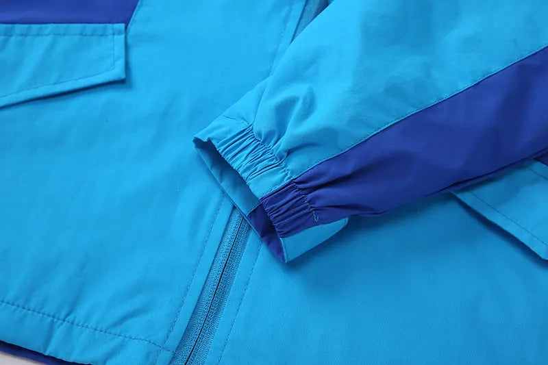 Blue children's long sleeve jacket with front zipper, shown on a hanger.