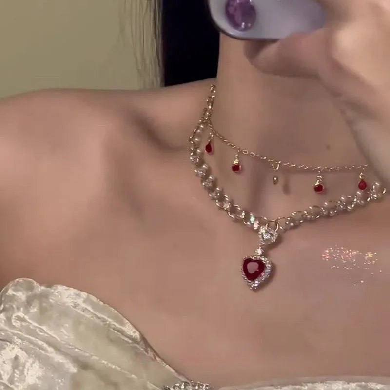Red double layer necklace with twin chains, a pearl pendant, and a love heart pendant on an adjustable alloy chain.