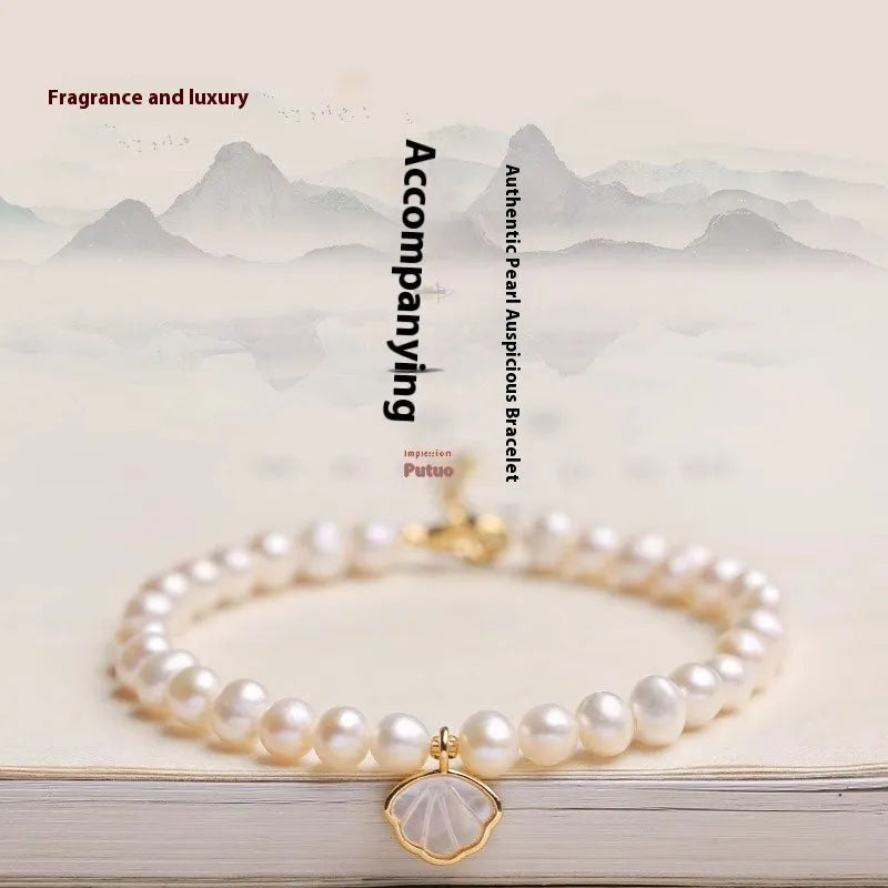 Women's freshwater pearl bracelet with fan-shaped design on a wrist, showing elastic and chain fastening options.