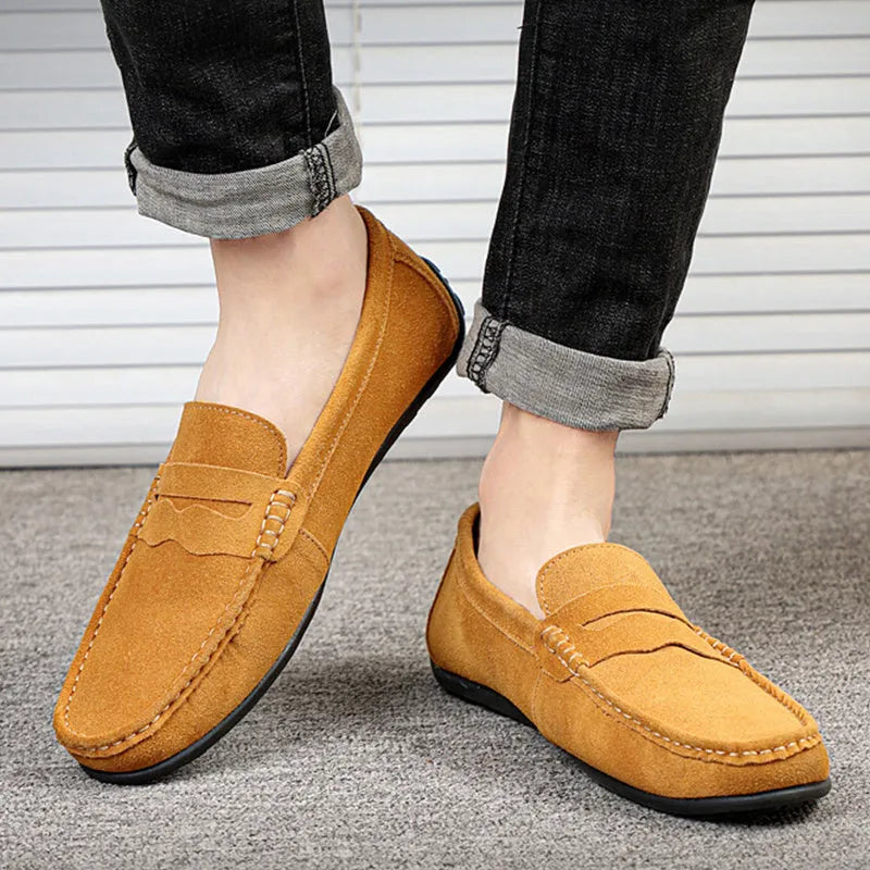 Men's brown suede slip-on loafers with round toe and flat rubber sole on a white background