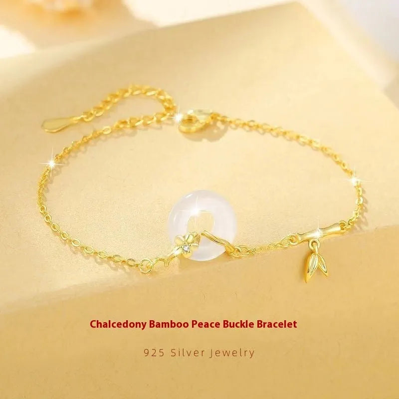 Gold tone women's bracelet with white chalcedony stone and adjustable peace symbol buckle closure