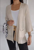 Women's waffle-knit cardigan coat in army green, showing texture and pocket detail.