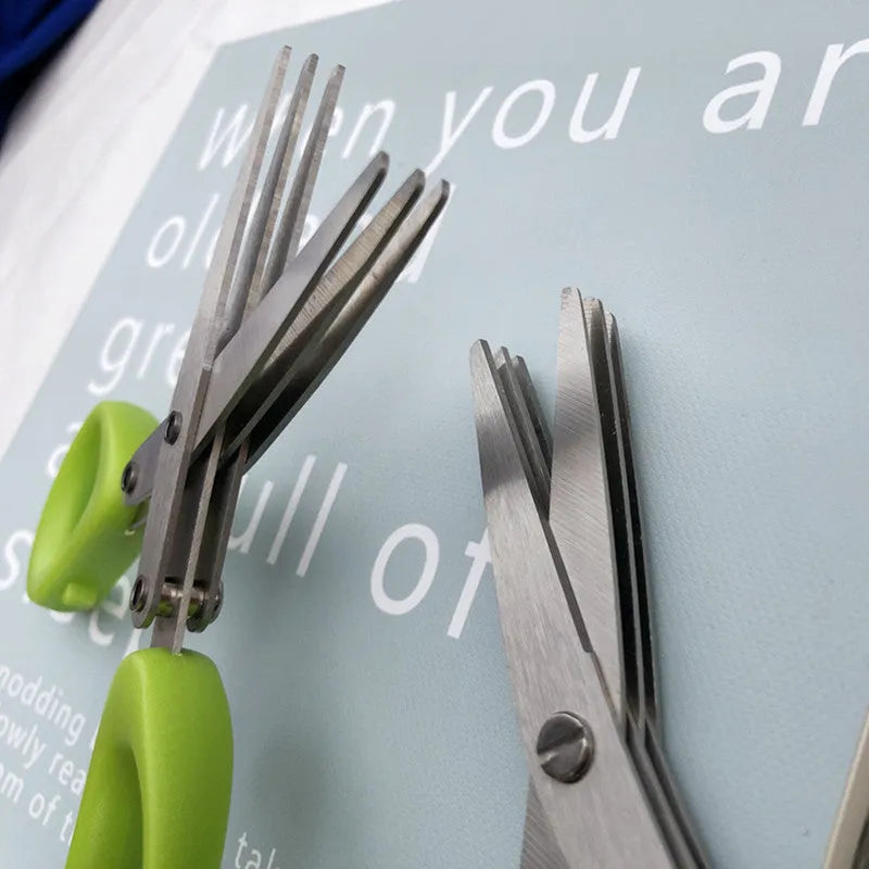Stainless steel multi-blade kitchen scissors for cutting onions and herbs on a chopping board.