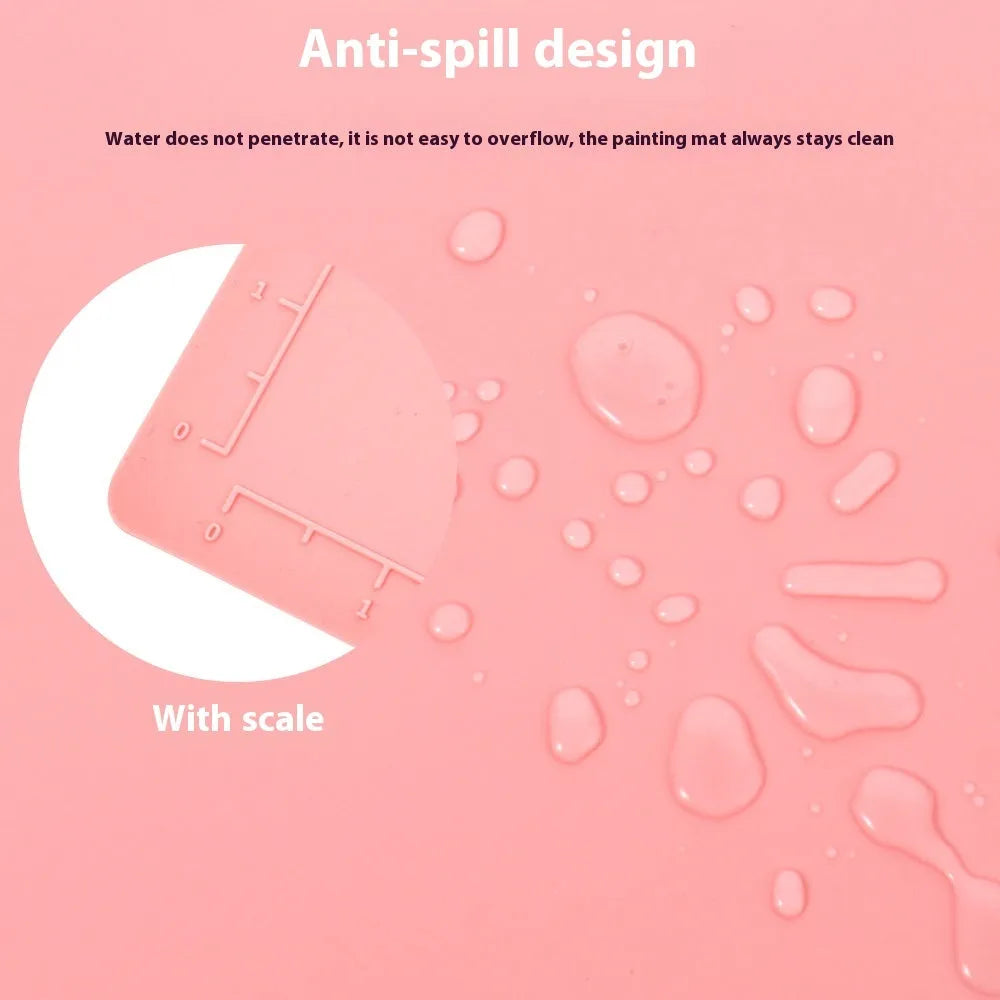 Light blue silicone painting mat with two integrated round bowls, laid flat on a wooden table.