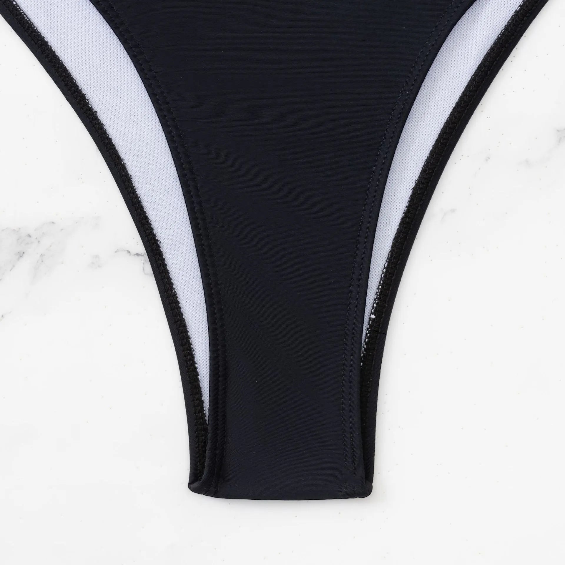 Black women's one-piece swimsuit with hollow cut-outs and white contrast stitching.