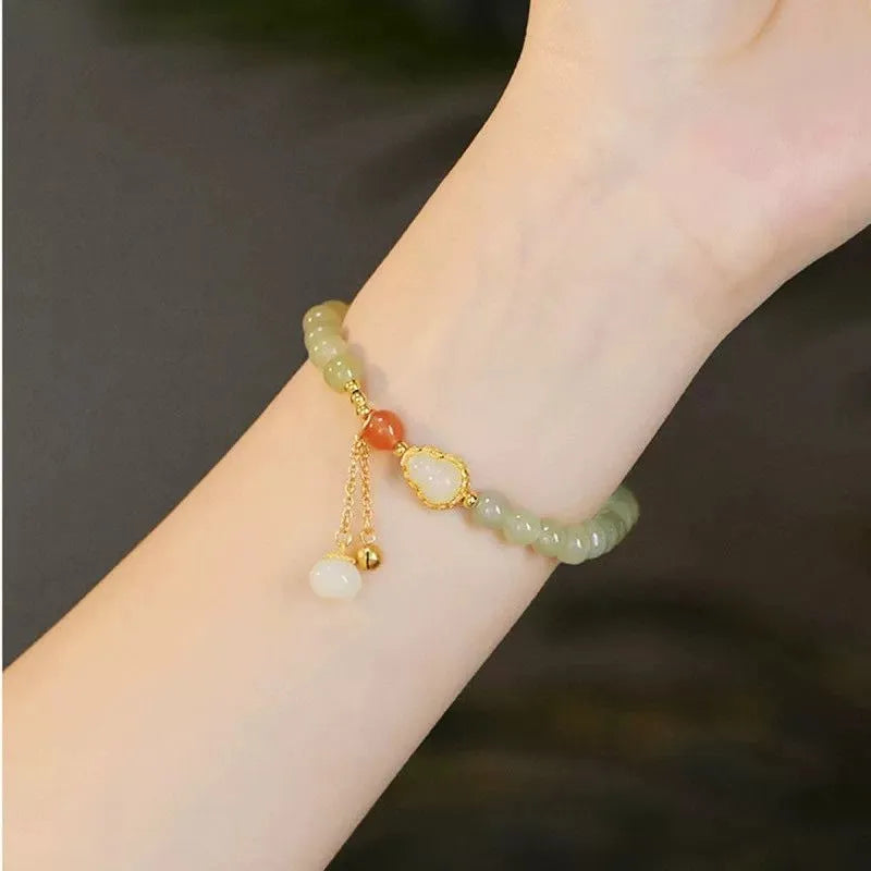 Women's jade bracelet with a 6mm gold-plated gourd charm and engraved fu character.