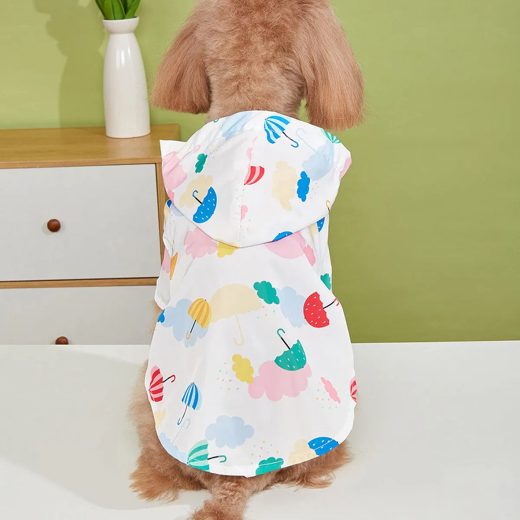 Colourful cartoon umbrella pattern dog raincoat on a model, showing four leg openings and polyester fabric.