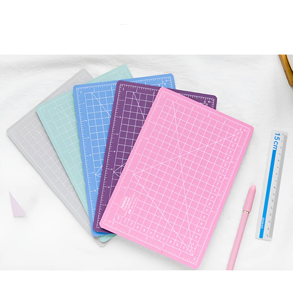 Art pen knife cutting board set showing coloured plastic mat, metal ruler, knife, sharpener, and blade.