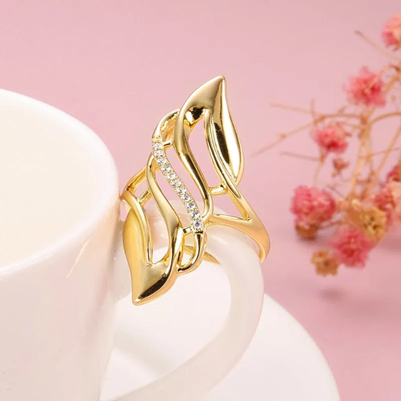 Gold coloured women's ring with exaggerated curved design on copper band