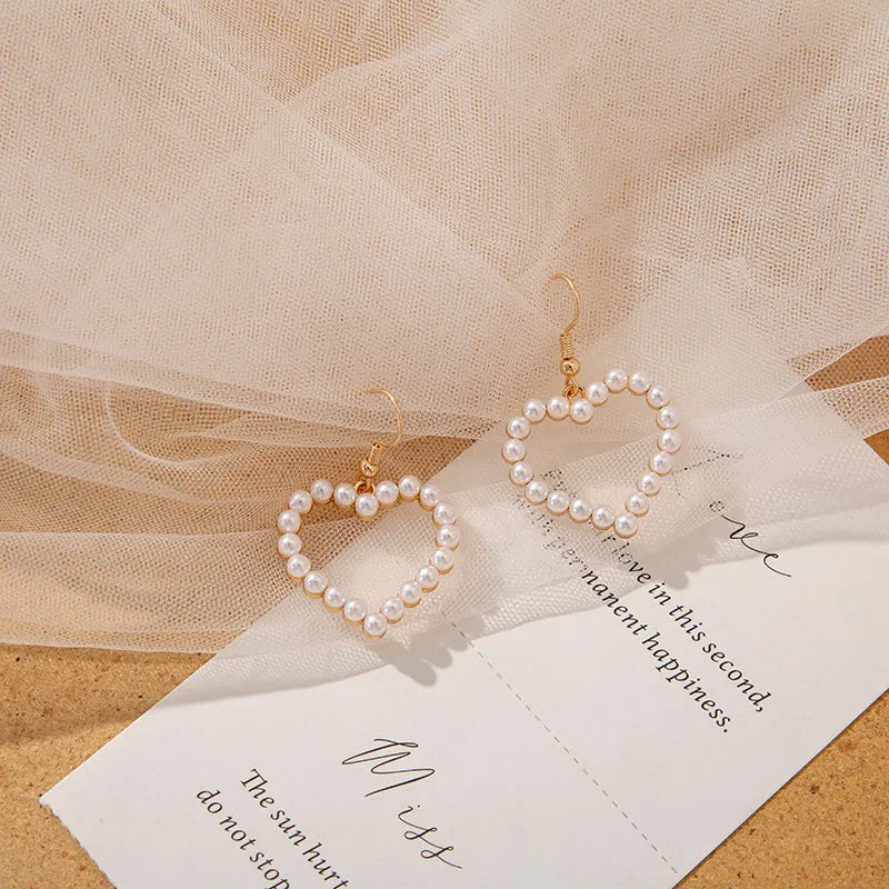 Heart shaped ear clip earrings for women with imitation pearl heart detail and retro round face, 1 pair