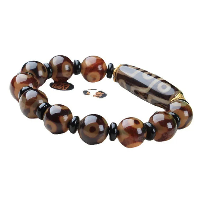 Distressed agate Tibet bead bracelet with three-eye design and polished finish on a wrist.