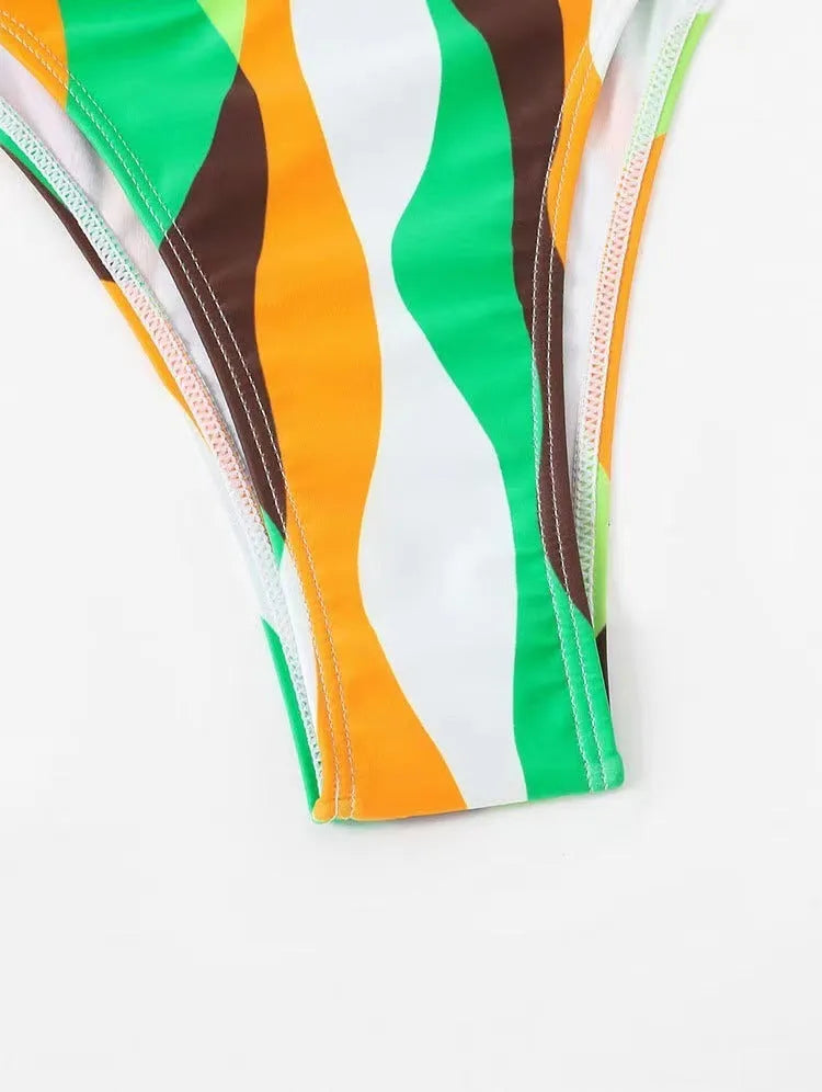 Women's yellow green three-piece bikini set with matching printed beach skirt laid flat.