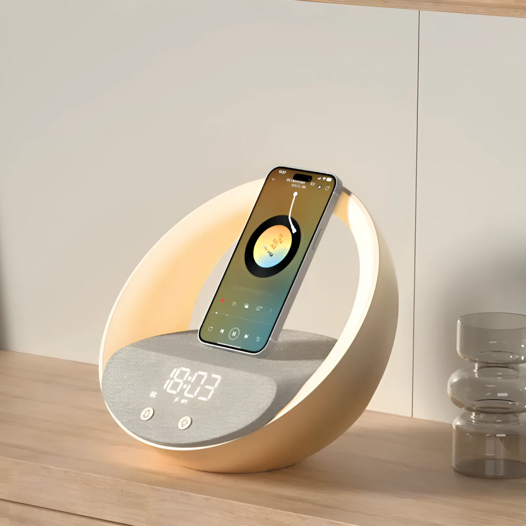 Beige multifunctional wireless charger clock with Bluetooth speaker and LED wake-up light on a bedside table.