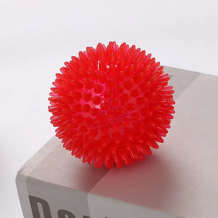 TPR spiky ball squeaker dog toy in red with textured surface for chewing and fetch games