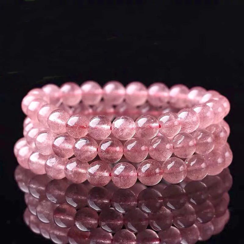 Women's strawberry quartz crystal bracelet with polished beads on an elastic cord, shown in 6mm, 8mm, and 10mm sizes.