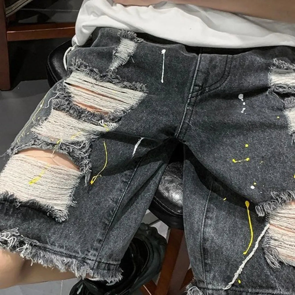 Man wearing loose-fit light blue water-washed denim shorts with hole details, for summer casual street style.