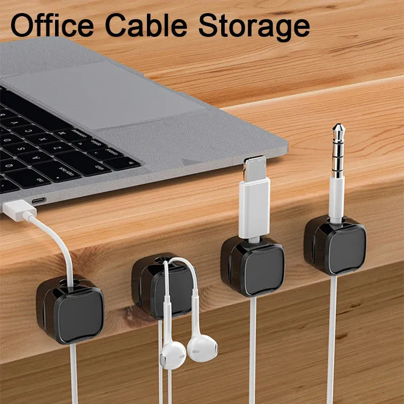 White and black magnetic cable clips with adhesive backing organising multiple cables under a desk