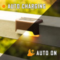 Set of four brown solar step lights with warm LED glow mounted on outdoor wooden stairs