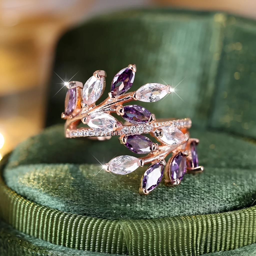 Adjustable copper leaf ring with a horse eye zircon stone in multiple colour finishes on a neutral background.