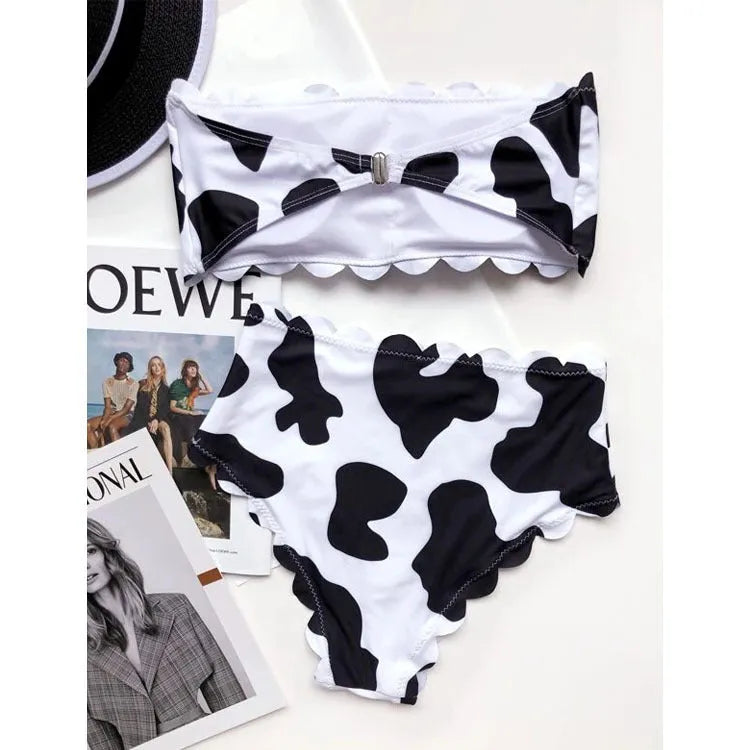 Women's black and white cow print bikini swimsuit with wrapped breast design on display