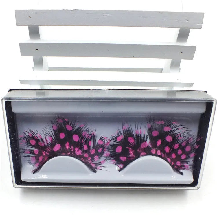 Handmade two-tone feather false eyelashes on a flat surface showing colour matching and feather texture