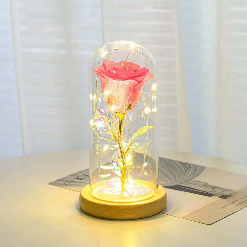 Glass dome covering a red eternal rose with coiled battery-powered LED lights on bendable copper wire.