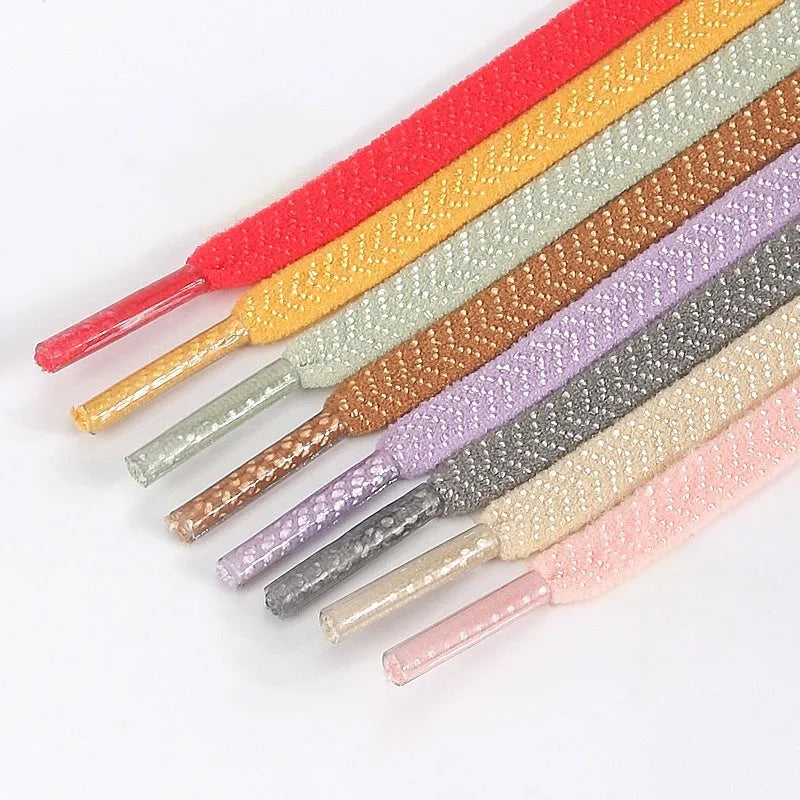 Flat elastic arrow pattern colour shoelace in black, 0.6cm wide, laid flat on a surface