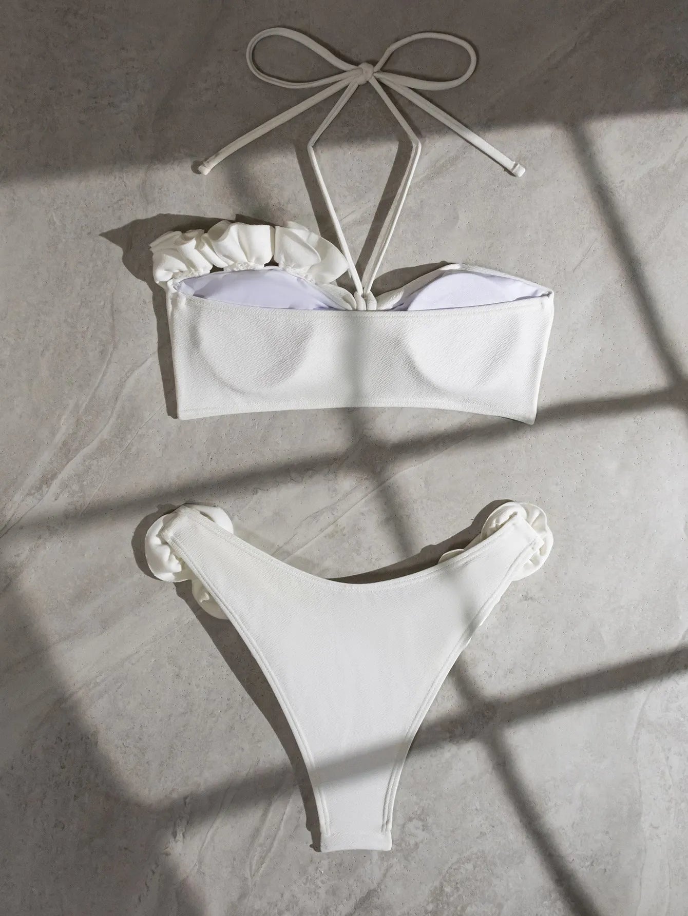 White women's halter lace-up swimsuit with three-dimensional floral design and briefs