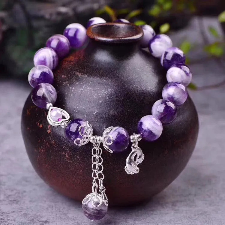 Natural amethyst bracelet with 10mm round beads on a woman's wrist.