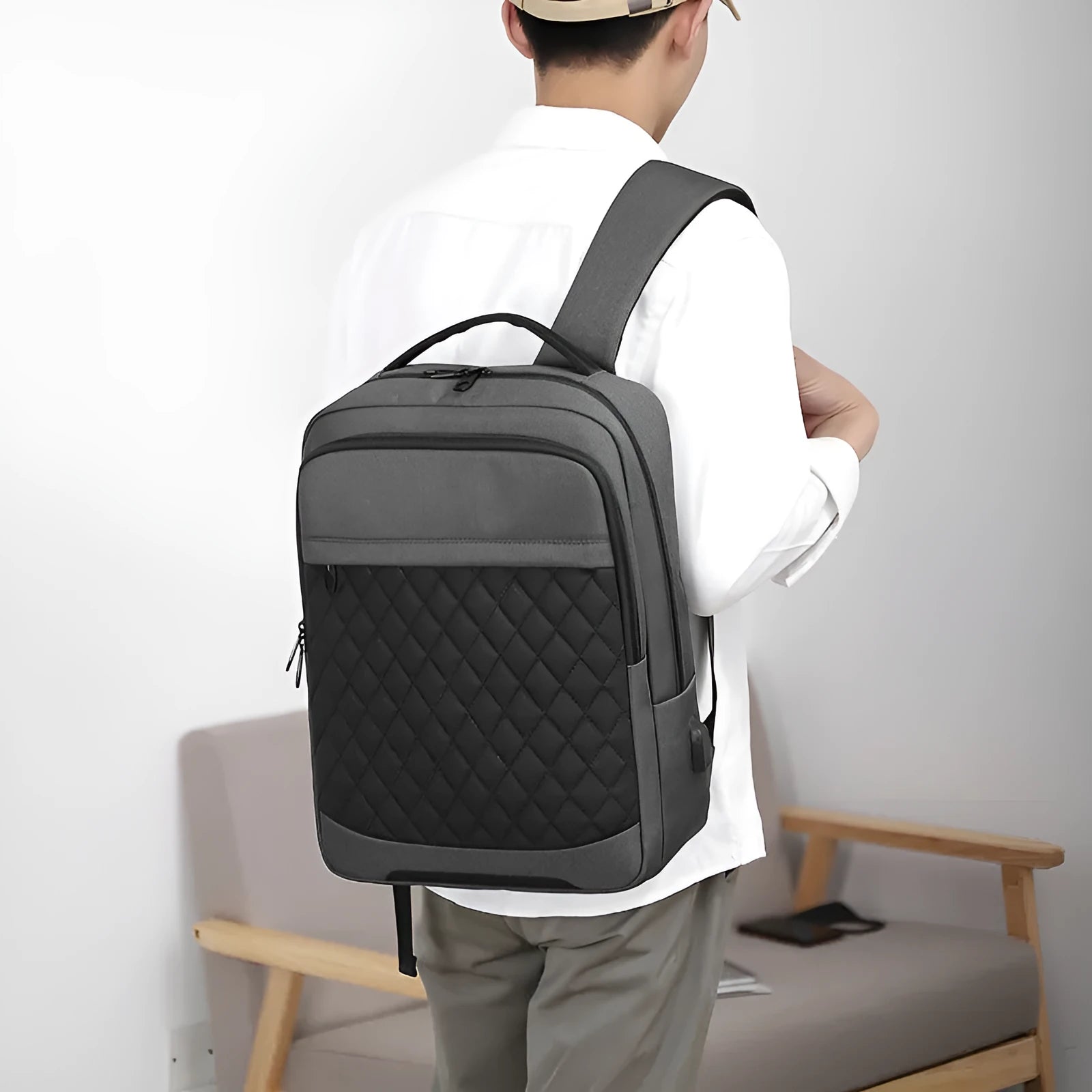 Men's solid colour Oxford cloth travel backpack with curved shoulder strap shown in black, blue, and grey.