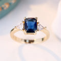 Rectangular copper ring with gold sapphire blue finish for women, shown in size options 6 to 13
