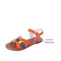 Women's orange buckle sandals with round toe, PU upper, and rubber sole on a neutral background