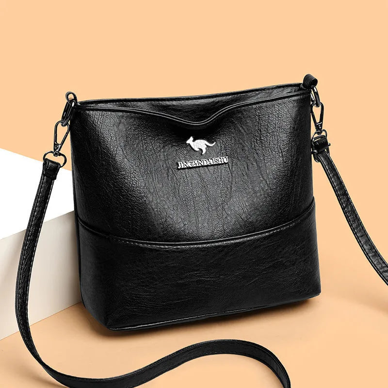 Women's PU leather crossbody bucket bag with wide strap, outer slit pocket, and internal phone and file pockets.