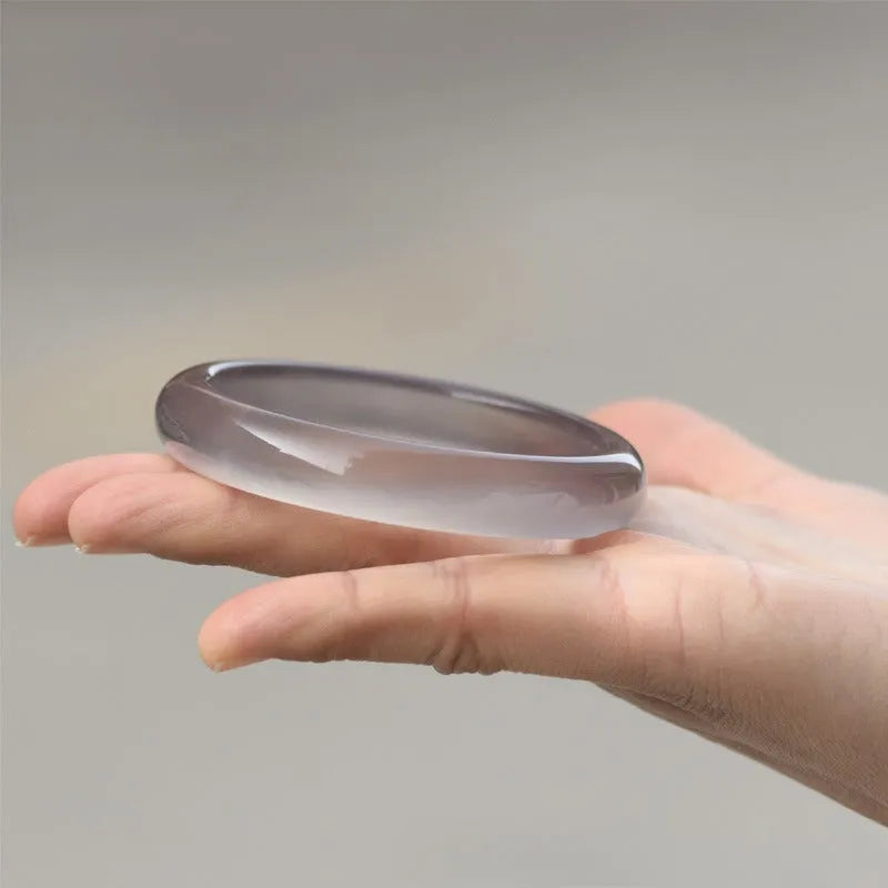 Dark grey iced chalcedony agate bracelet with a continuous circle design on a wrist.