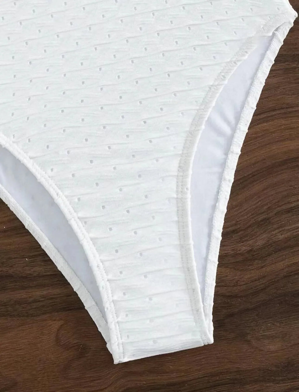White women's one-piece swimsuit with sling style and brief cut design on mannequin