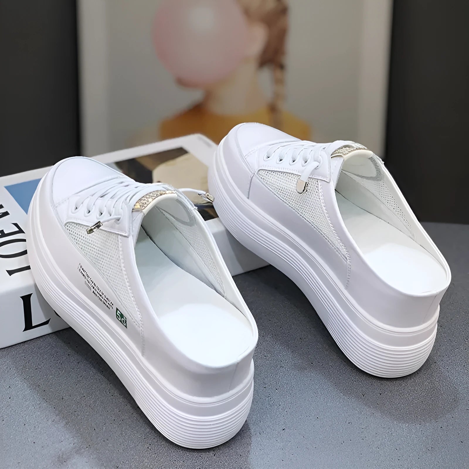 White women's platform trainers with mesh panels and a round toe on a rubber sole.