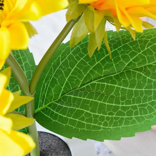 Rechargeable artificial sunflower LED night light on a table with USB charging cable.