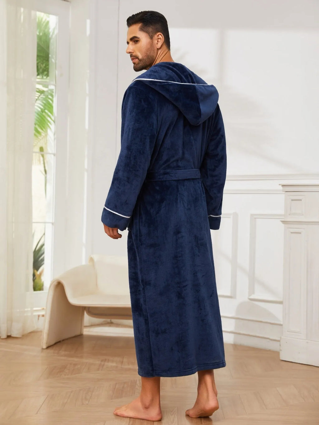 Man wearing a light grey flannel-style bathrobe at home, showing the front wrap design and soft texture.
