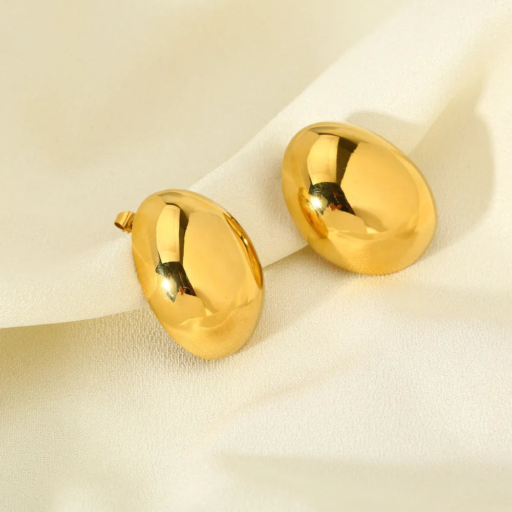 Geometric stainless steel ear studs with a gold electroplated finish and exaggerated glazed surface.