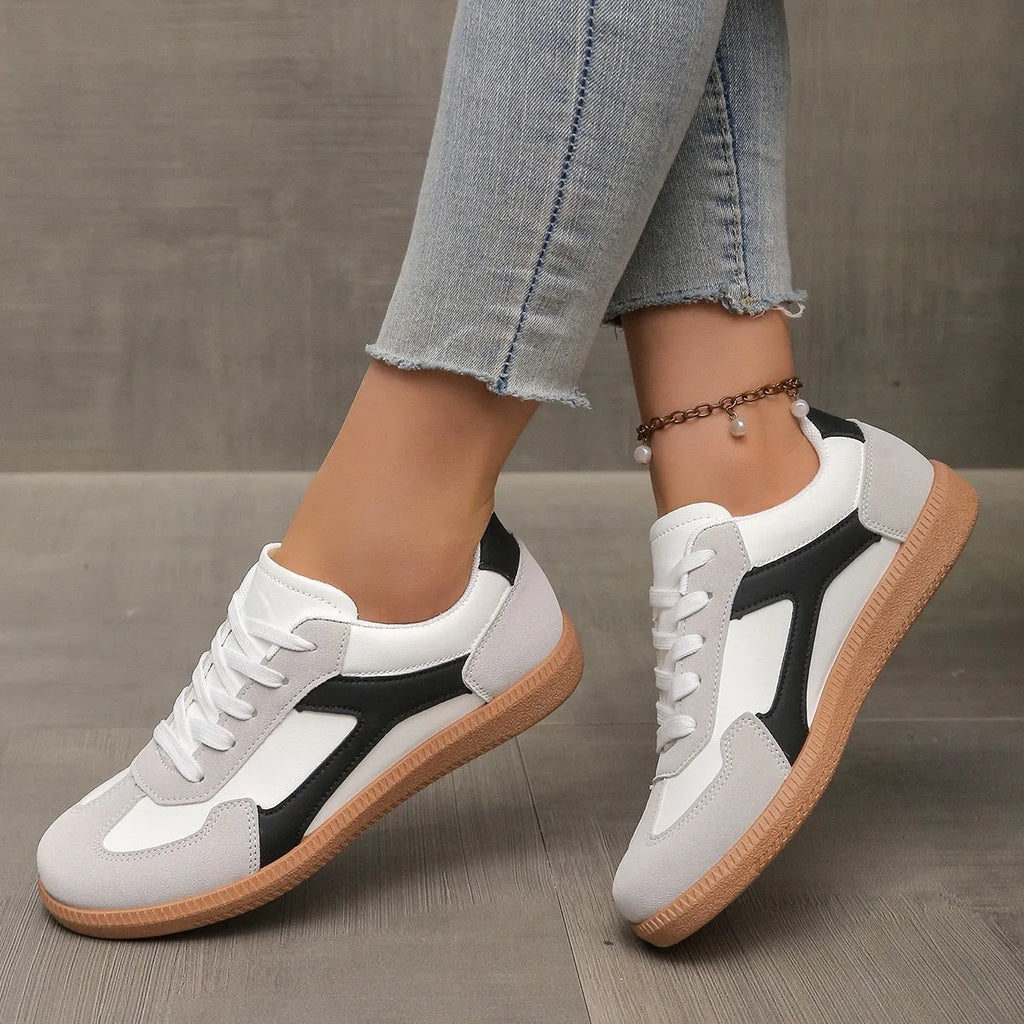 Plus size low-top sneaker in artificial PU with flat rubber sole and lace-up front, shown in multiple colour options.