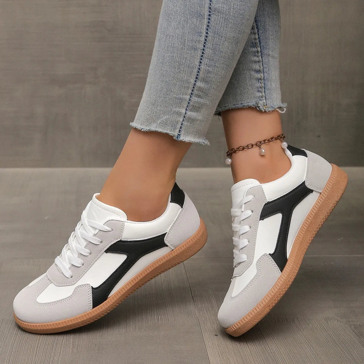 Plus size low-top sneaker in artificial PU with flat rubber sole and lace-up front, shown in multiple colour options.