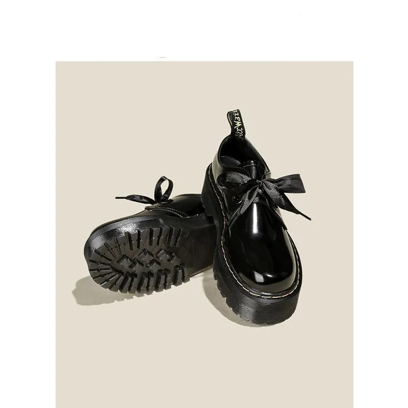 Black and white women's thick-soled small leather shoes with lace-up closure, ribbons, and cross straps.