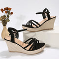 Women's beige and black cloth wedge sandals with a fish mouth open toe design.